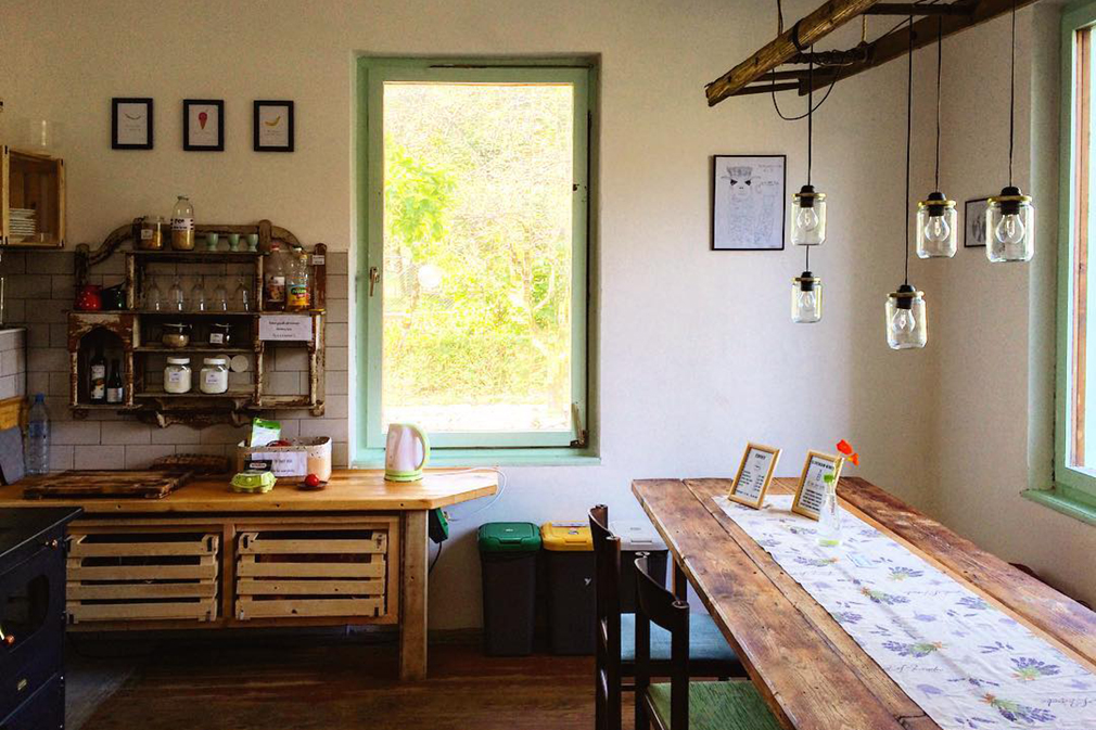 Rustic kitchen with large wooden dining table and mason jar hanging lamps