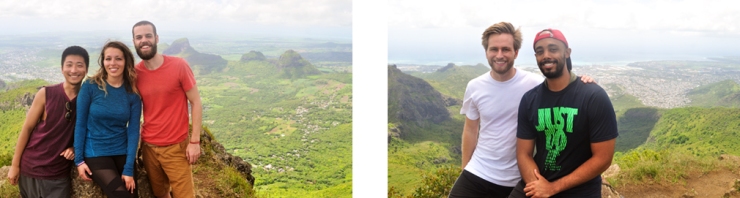A group of smiling, young hikers pose in front of tropical panoramic views