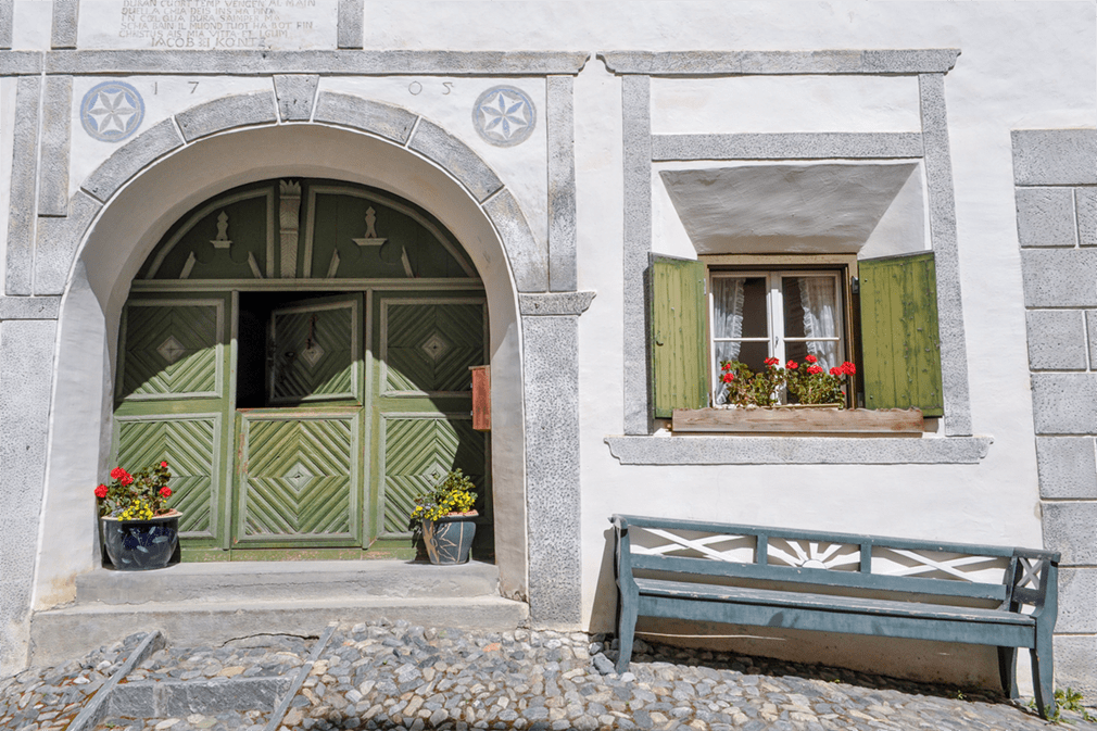 The façade of an old building with wooden door and window shutters