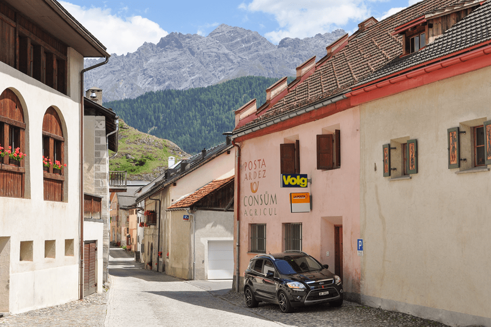 Car parked outside of an old postal building in a small Alpine village