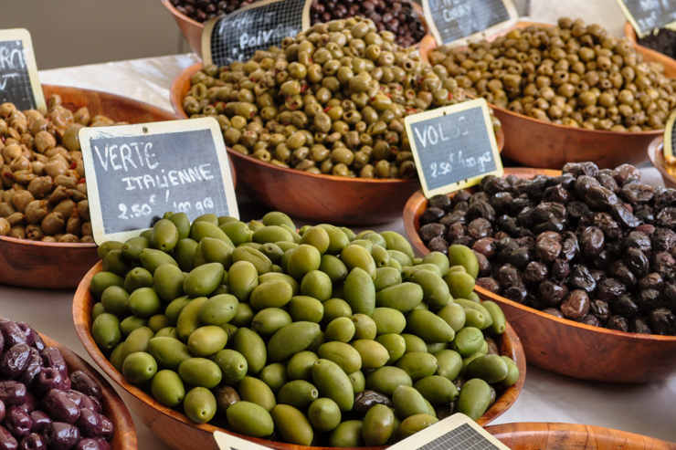 Bowls of colorful olives on display in open-air market