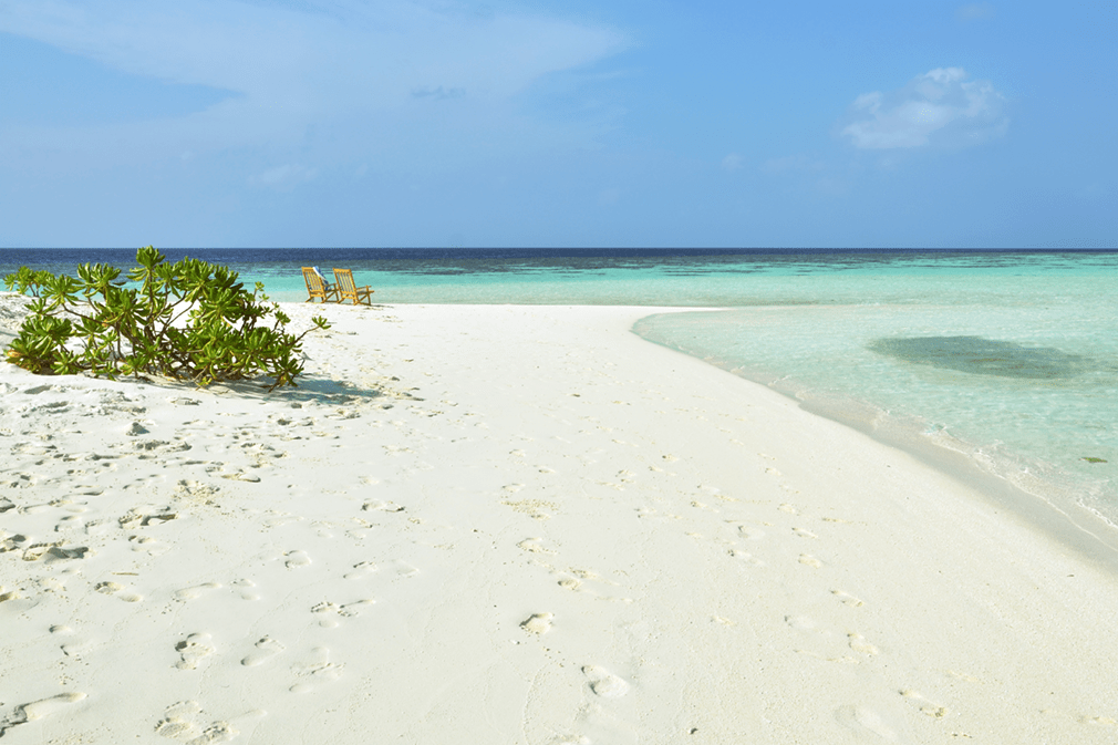 Two deck chairs on pristine sandy beach