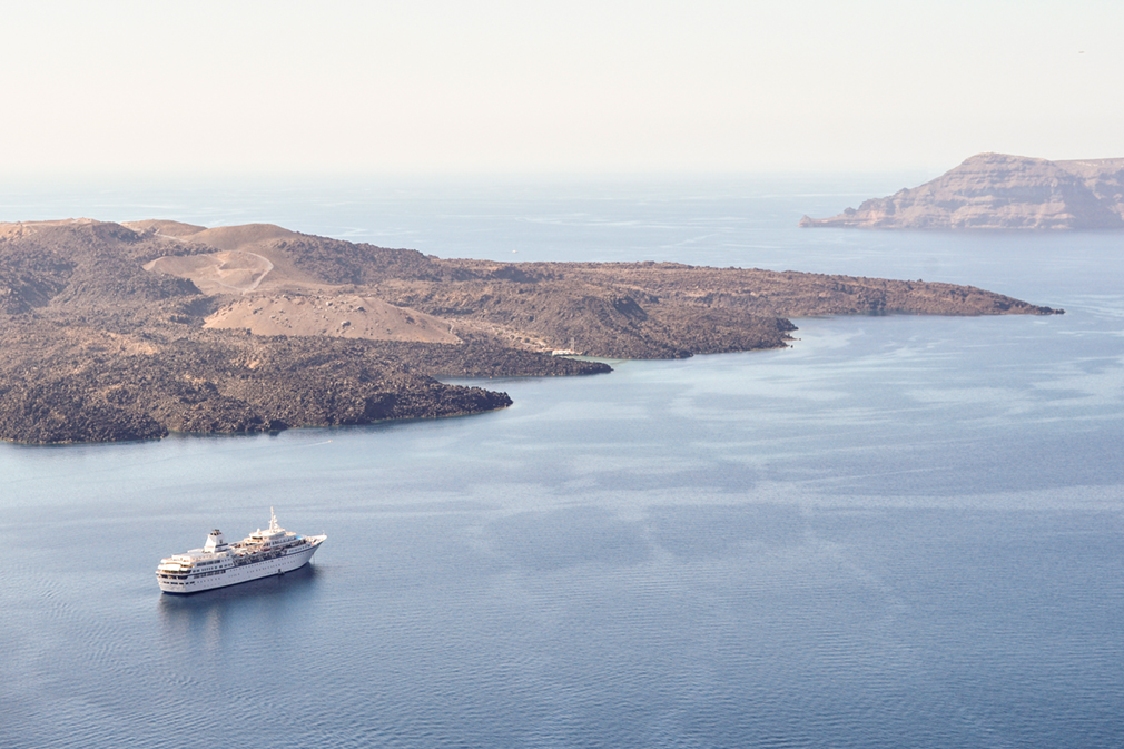Cruise ship sailing past arid island