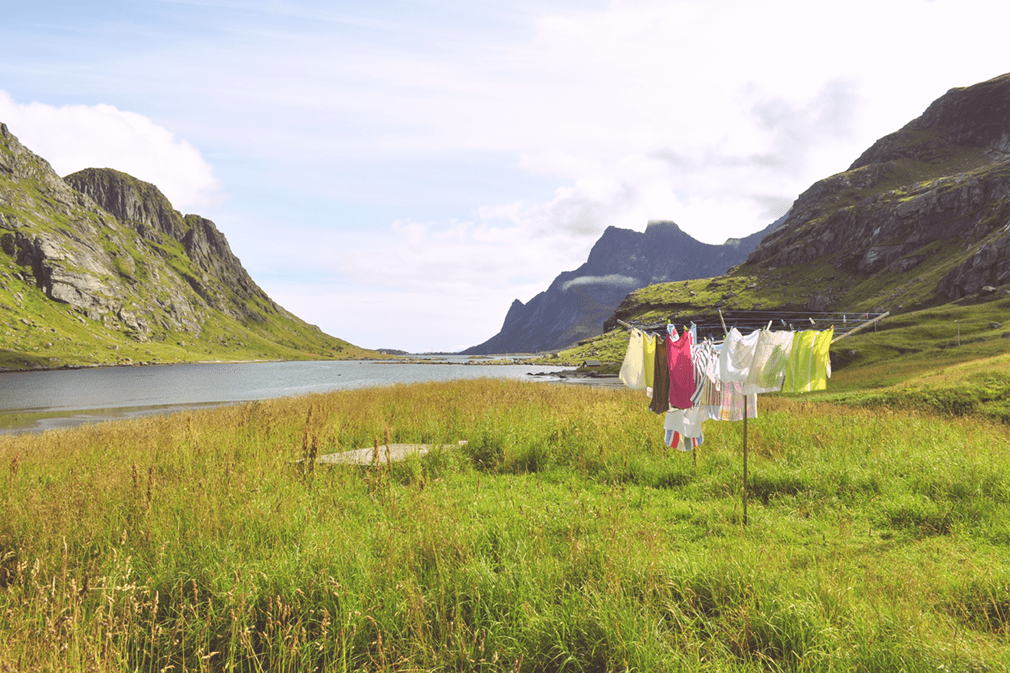 Clothes drying on an umbrella clothesline by a fjord