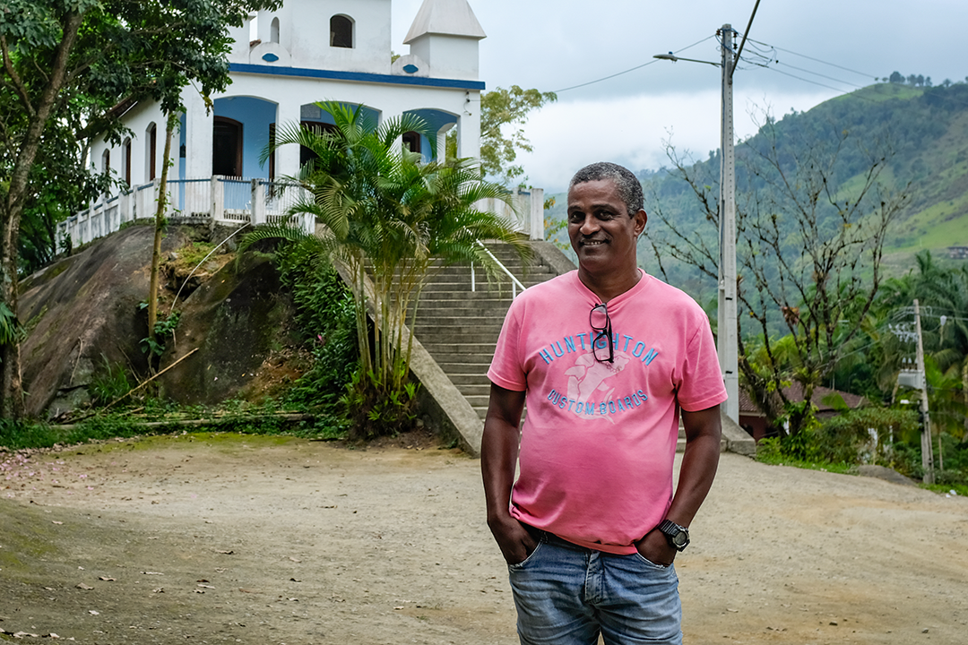 Man in pink shirt posing in front of a church