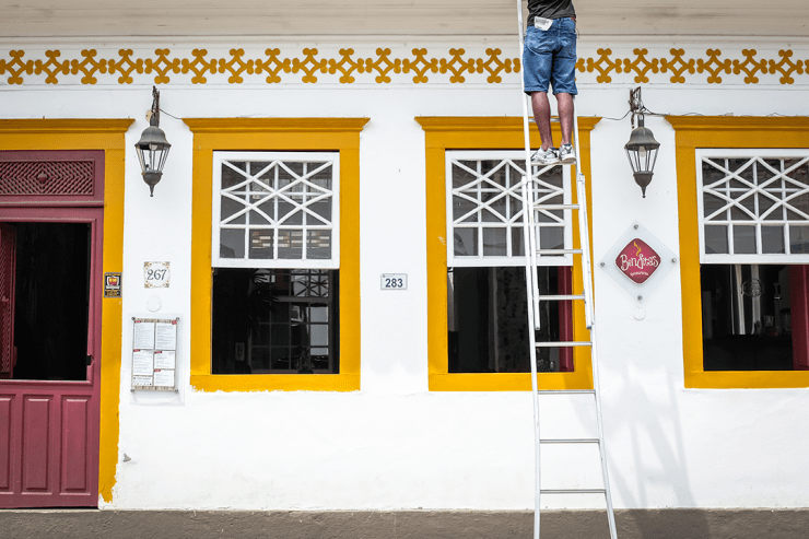 A carpenter works on restoring a colonial building