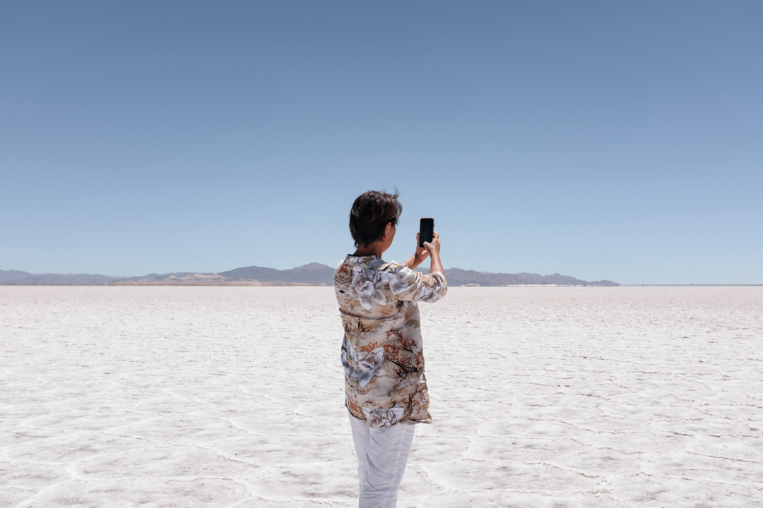 A woman taking a photo of salt flats