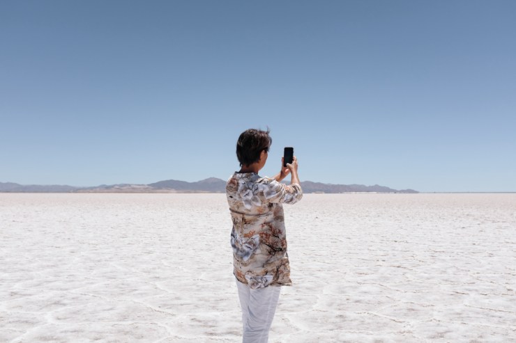 A woman taking a photo of salt flats