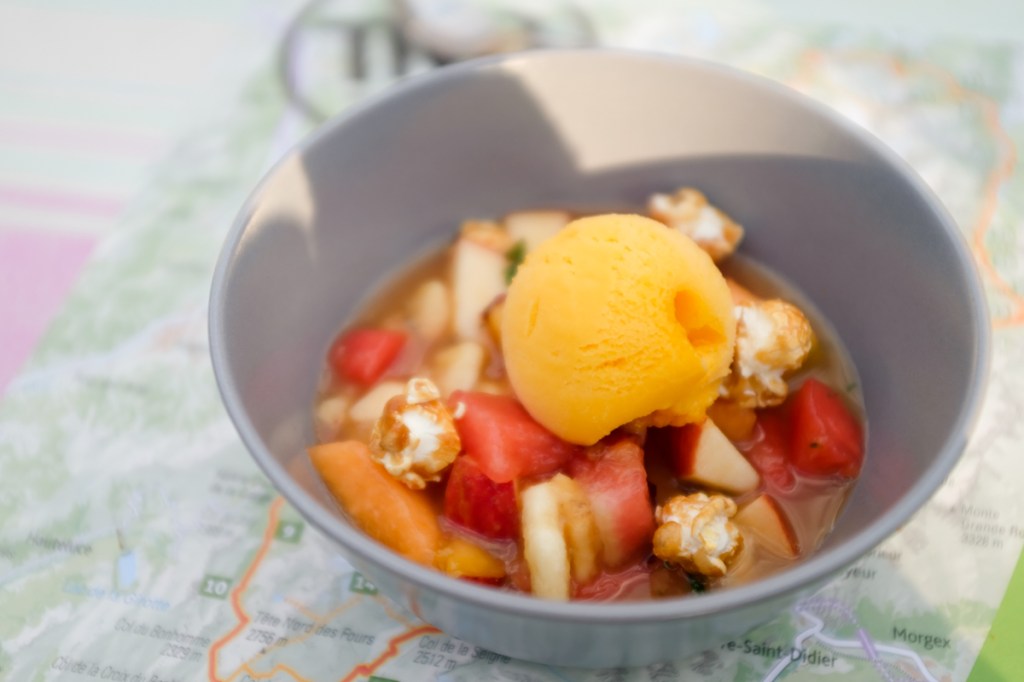 A dessert of watermelon, melon, apples, caramelized popcorn, and ice cream