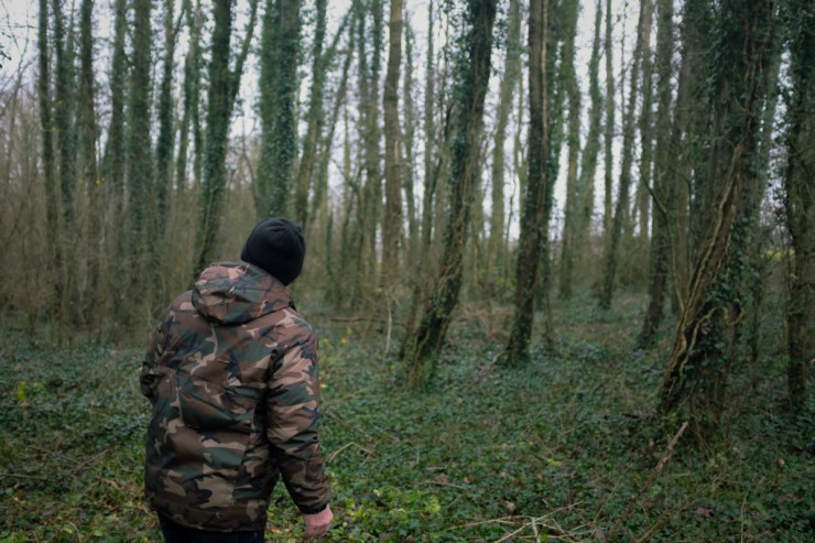 Man in camo jacket surveying a forest