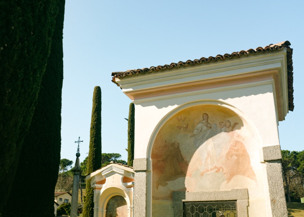 A fresco in a churchyard with cypress trees