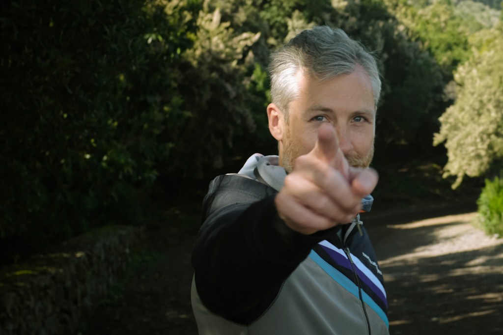 Smiling man pointing at camera