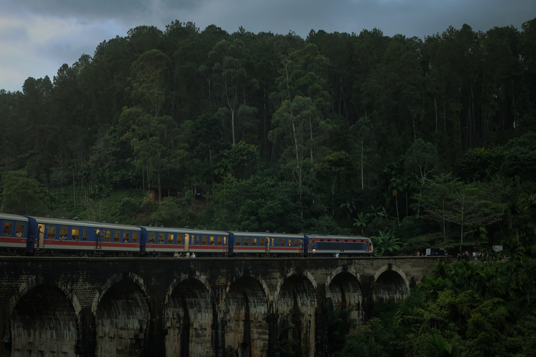 A train passes over a colonial-era railway bridge