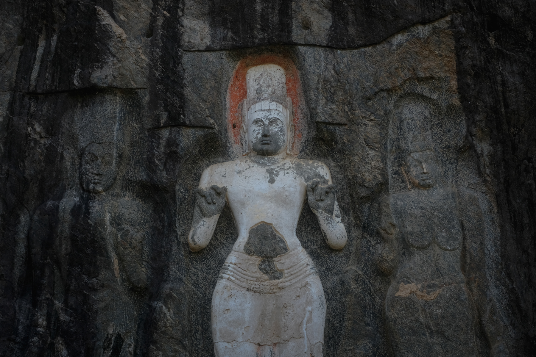 Rock carvings of three Buddhist figures