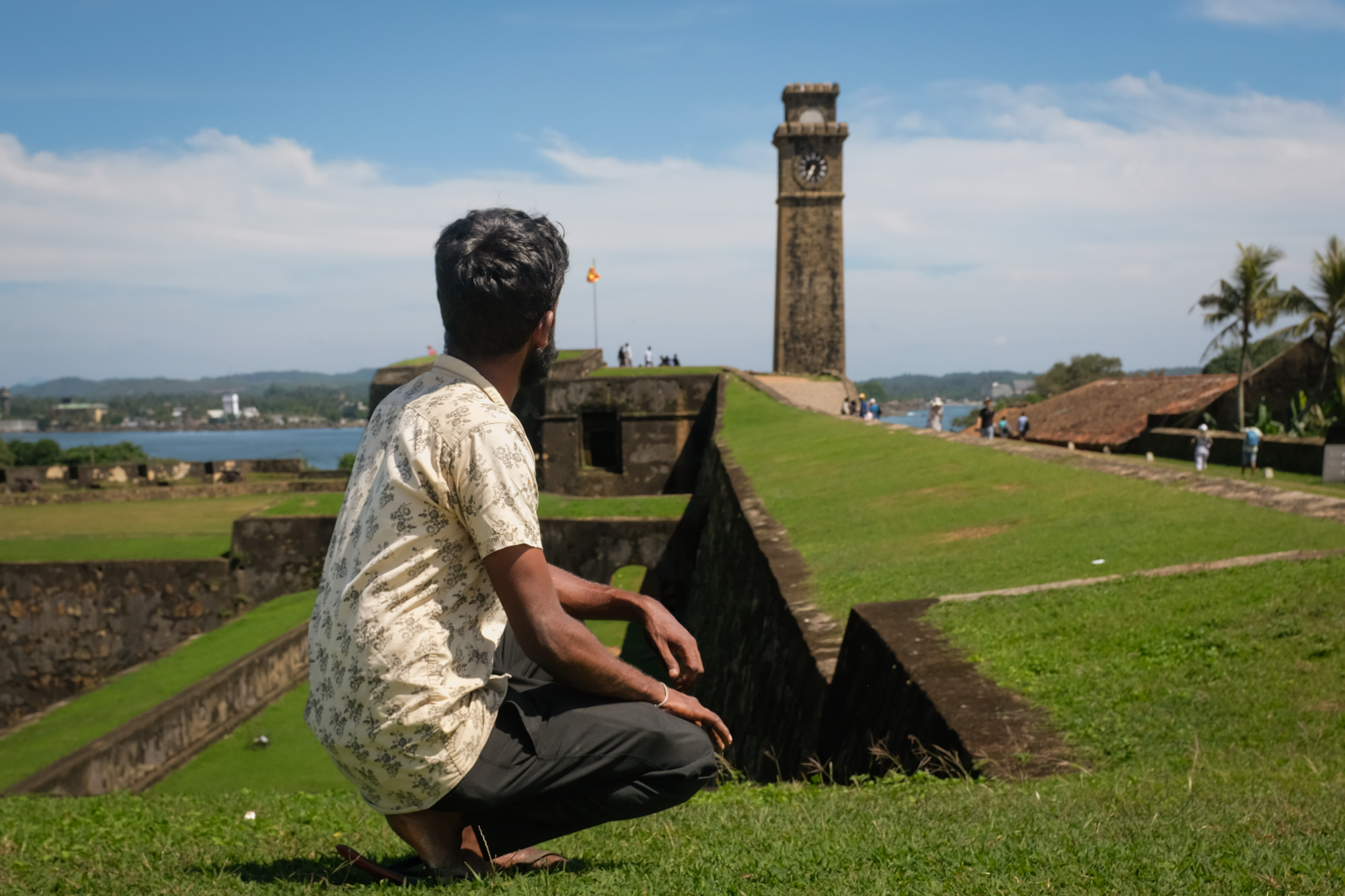 A man poses in front of a colonial clock tower