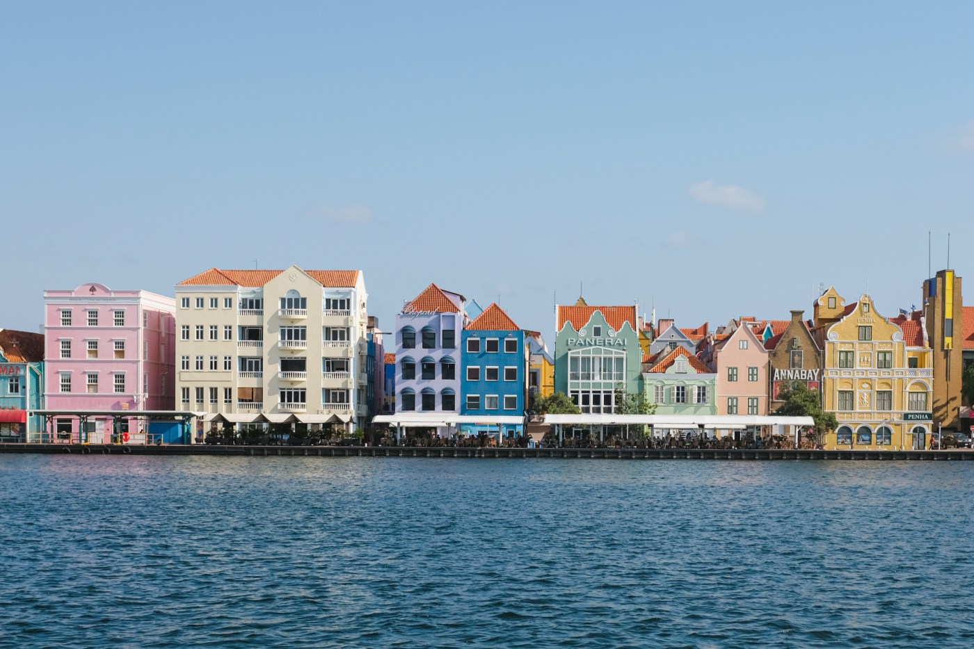 A row of pastel-colored colonial houses by the water