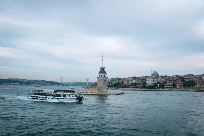 A ferry sails past an island tower
