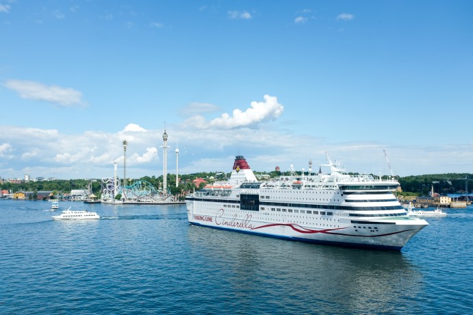 A cruise ship sailing in front of an amuse park
